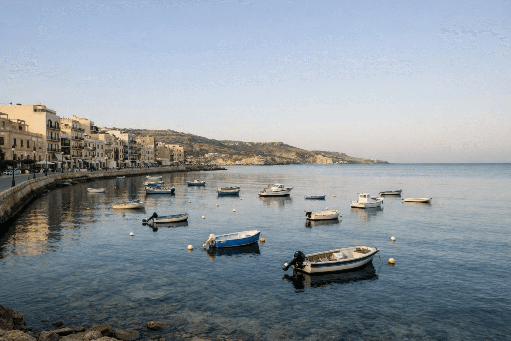 Marsalforn Bay on Gozo Malta with open seafront promenade and fishing boats