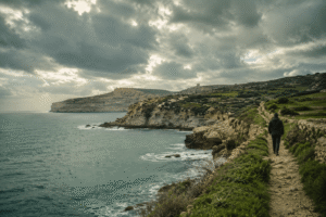 Gozo in Winter: Is It Worth Visiting? Quiet winter coastline in Gozo with dramatic clouds, limestone cliffs, and soft Mediterranean light.
