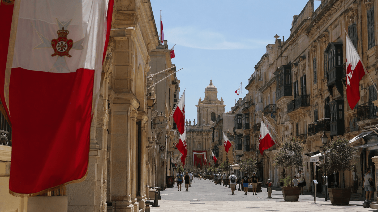 Historic streets in Malta decorated with flags during a national public holiday.