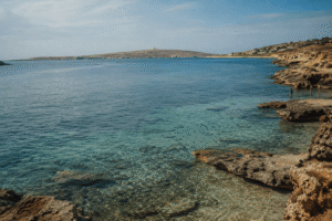 Crystal-clear water at Hondoq ir-Rummien in Gozo with rocky shoreline and distant views of Comino.