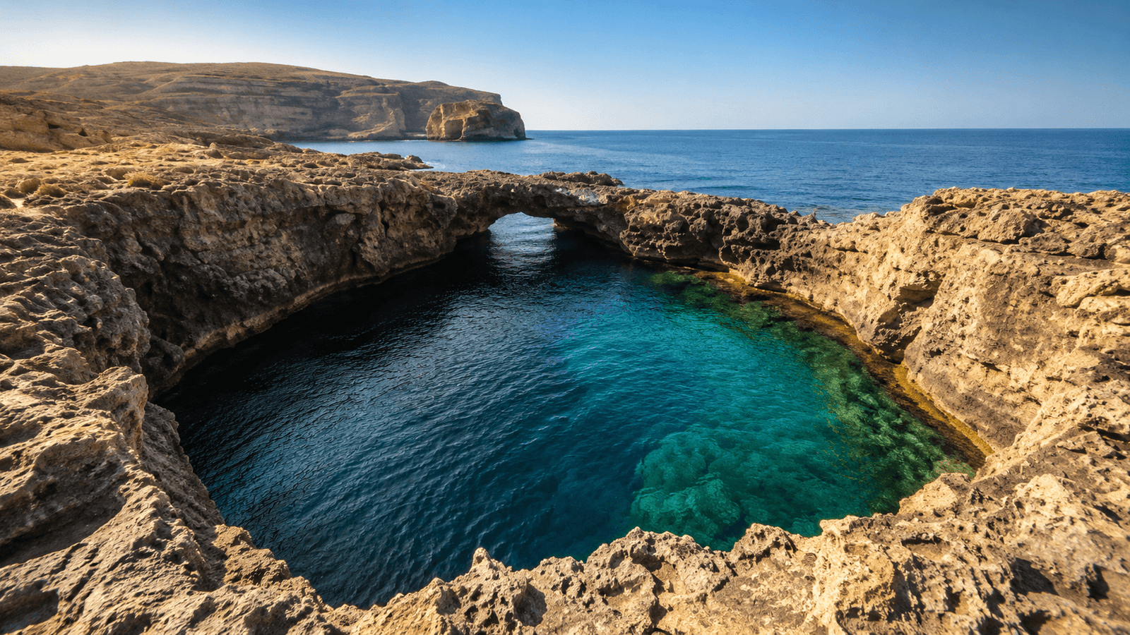 The Blue Hole at Dwejra in Gozo with clear turquoise water surrounded by limestone rock formations.